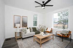 Living room with wood finished floors, a ceiling fan, and baseboards