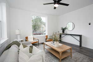 Living area featuring wood finished floors, a ceiling fan, and baseboards