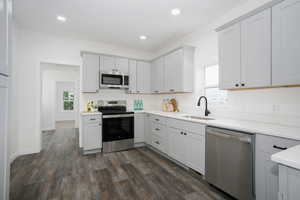 Kitchen featuring appliances with stainless steel finishes, a sink, plenty of natural light, light countertops, and recessed lighting