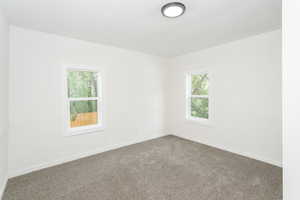 Spare room featuring healthy amount of natural light, carpet, and baseboards