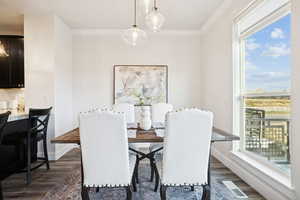 Dining area featuring dark wood finished floors and crown molding