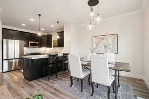 Dining area with recessed lighting and light wood-style floors