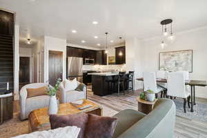 Living room with recessed lighting, light wood finished floors, and stairway