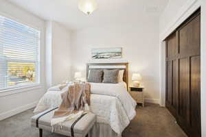 Carpeted bedroom with a closet and baseboards