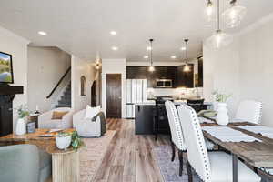 Dining space featuring recessed lighting, light wood-type flooring, stairs, and crown molding