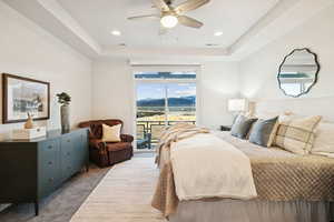Carpeted bedroom with a raised ceiling, access to outside, a ceiling fan, a mountain view, and recessed lighting