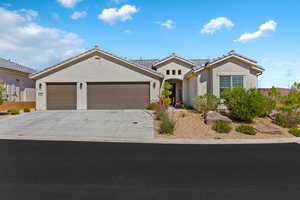 Single story home with a garage, stucco siding, driveway, and a tile roof
