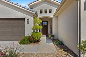Property entrance with a garage and stucco siding