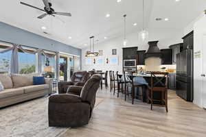 Living area featuring a ceiling fan, light wood-style floors, recessed lighting, and high vaulted ceiling