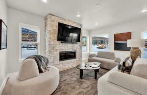 Living room featuring a stone fireplace, recessed lighting, wood finished floors, and baseboards