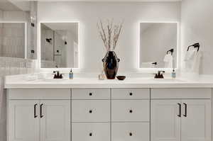 Bathroom featuring double vanity and a shower stall