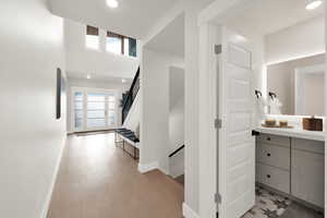 Hall featuring baseboards, recessed lighting, and stairs