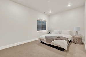 Carpeted bedroom with baseboards and recessed lighting