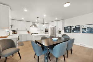 Dining area with recessed lighting, light wood-style floors, and baseboards