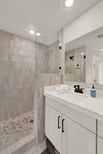 Bathroom with walk in shower, vanity, and recessed lighting
