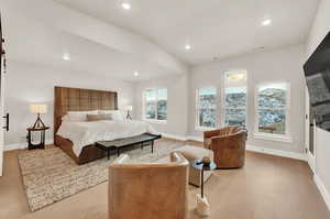 Bedroom with light wood finished floors, baseboards, recessed lighting, and lofted ceiling