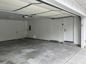 Garage featuring electric panel and a garage door opener