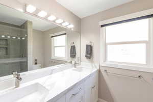 Full bathroom featuring double vanity, quartz countertops, tiled shower, and toilet. (See virtual tour for better views of entire bathroom including shower)