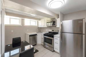 Basement kitchen with stainless steel appliances. Hardwood floors.