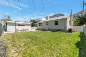 Large back yard (mostly fenced) features a patio with gas firepit, bistro lights and patio furniture for a great space to unwind during downtime.