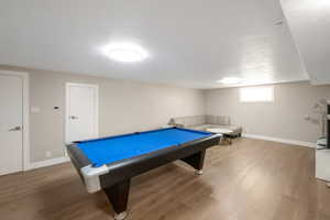 Basement family room features hard wood floors, pool table, sectional, marble end tables and an 85 inch flat screen. All included.