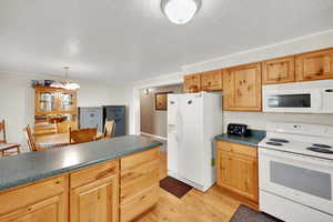 Kitchen with white appliances and stunning cabinets.