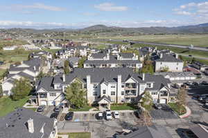 Aerial view of property and surrounding area with a mountainous background and nearby suburban area
