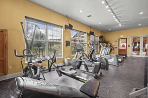 Gym featuring baseboards and rail lighting