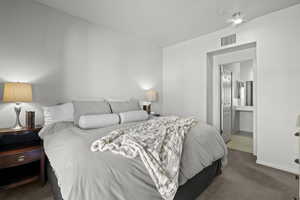 Bedroom featuring carpet flooring, ensuite bath, and baseboards