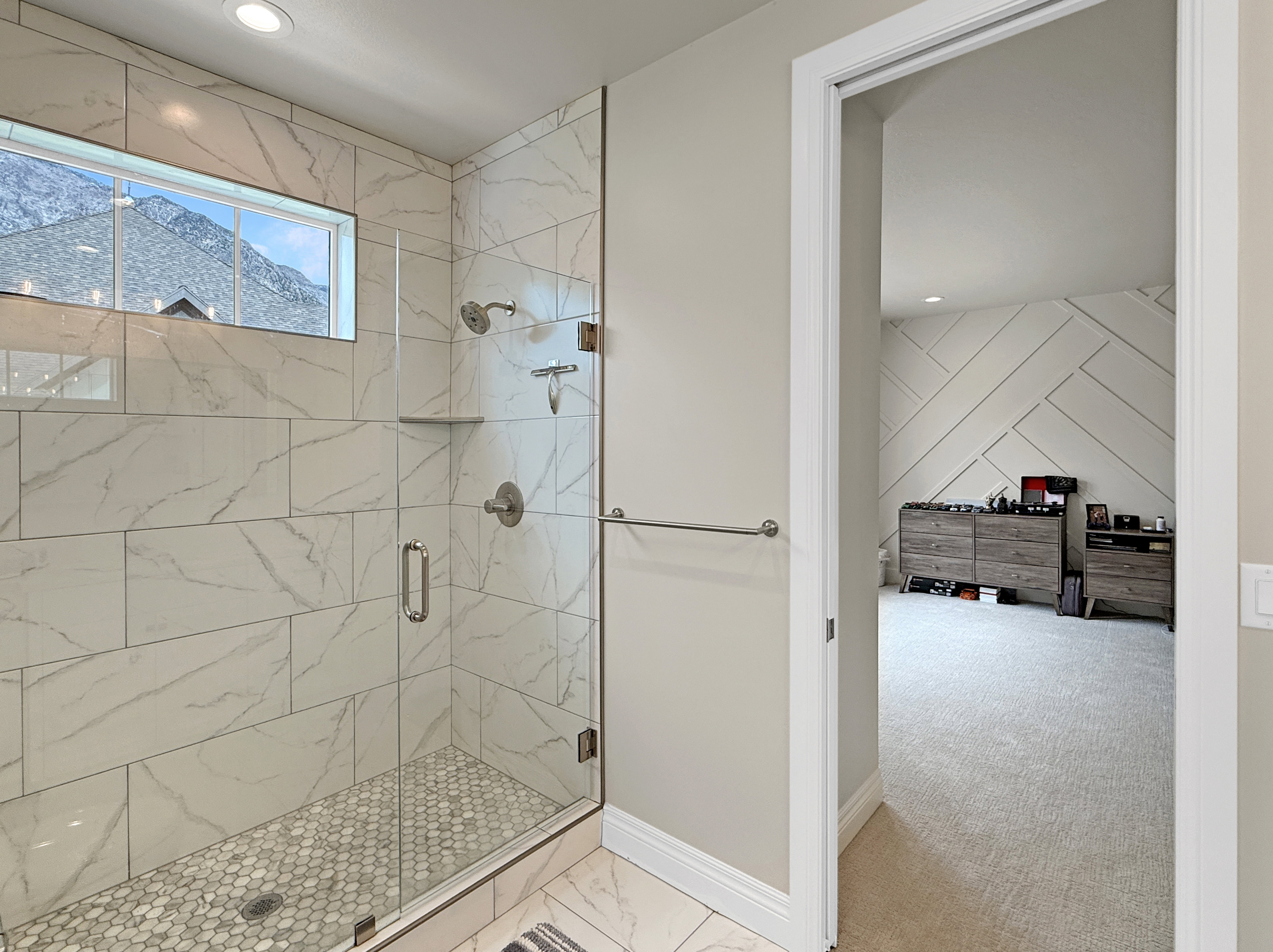 Bathroom with a shower stall, marble look tiles, baseboards, and recessed lighting