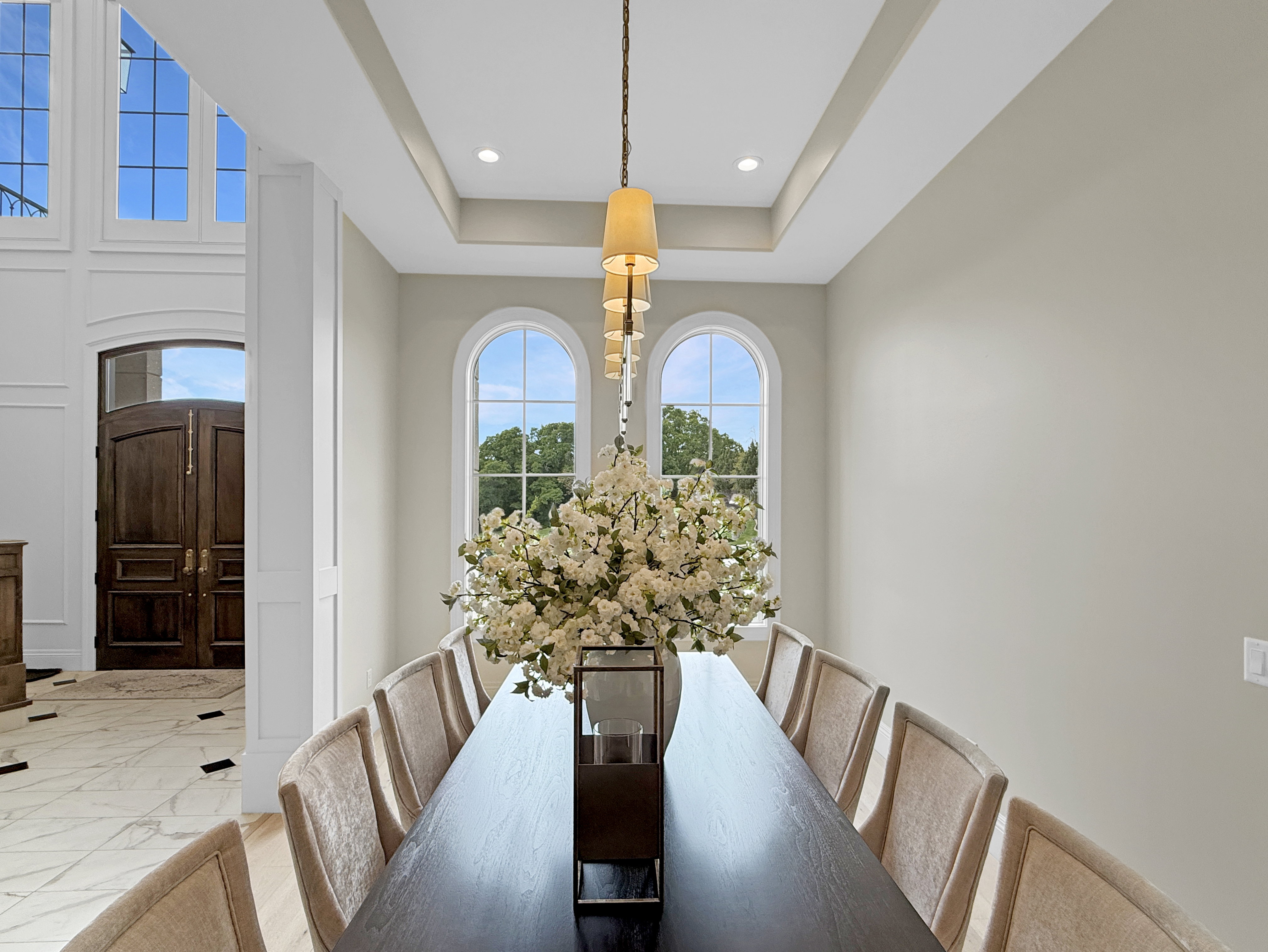 Dining space with marble finish flooring, recessed lighting, and a tray ceiling