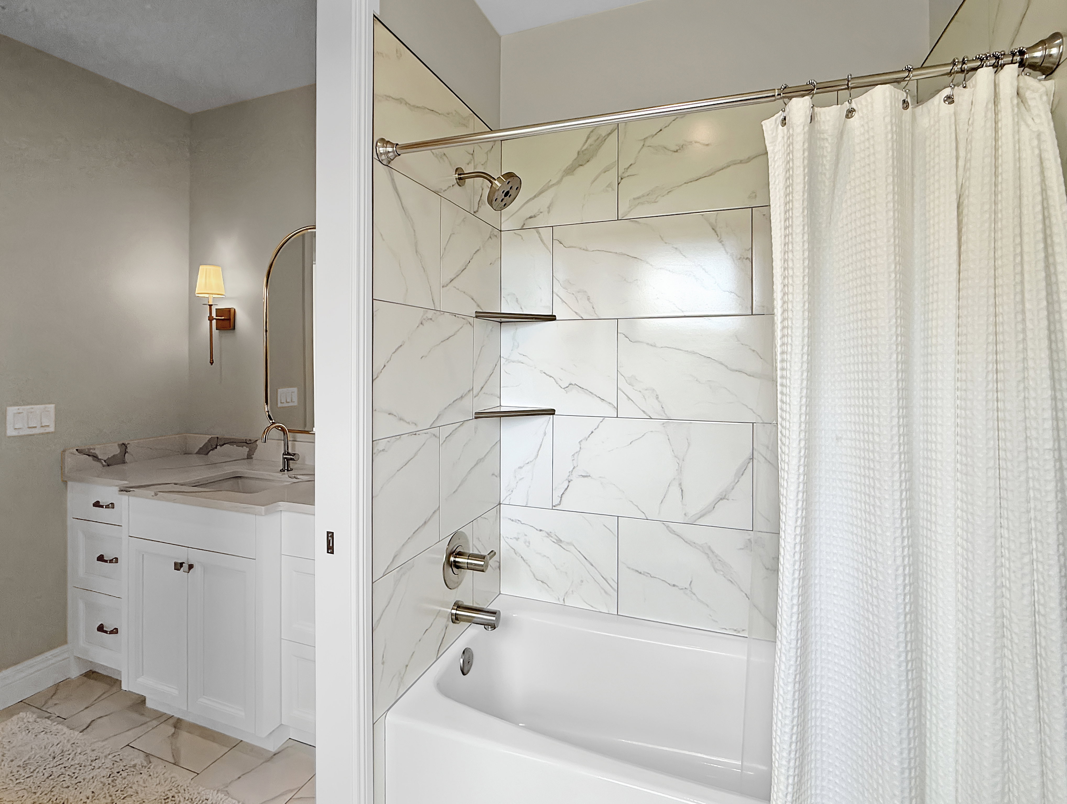Full bathroom featuring shower / bath combo with shower curtain, vanity, and marble look tiles