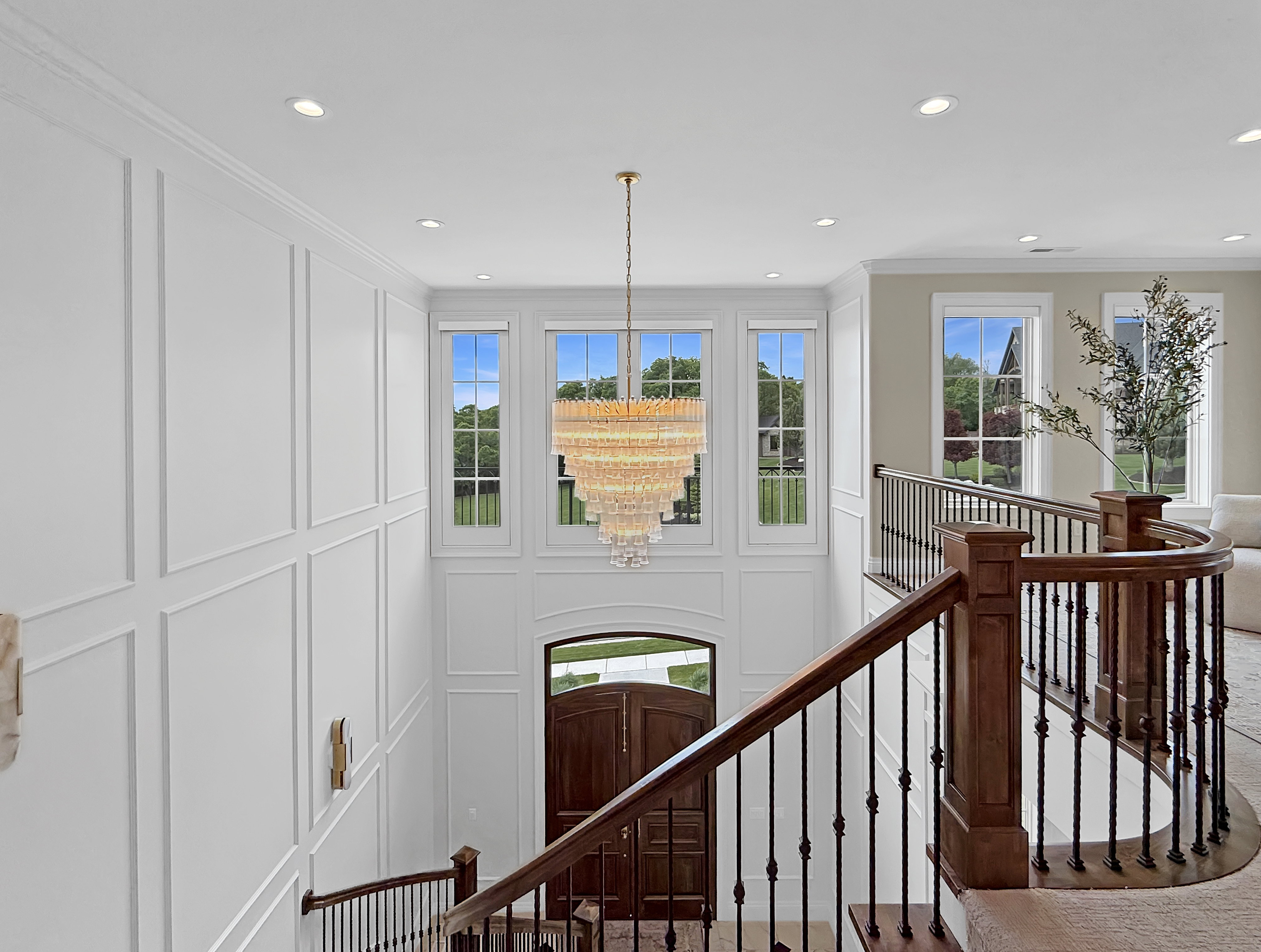 Stairs featuring a decorative wall, recessed lighting, crown molding, and a chandelier