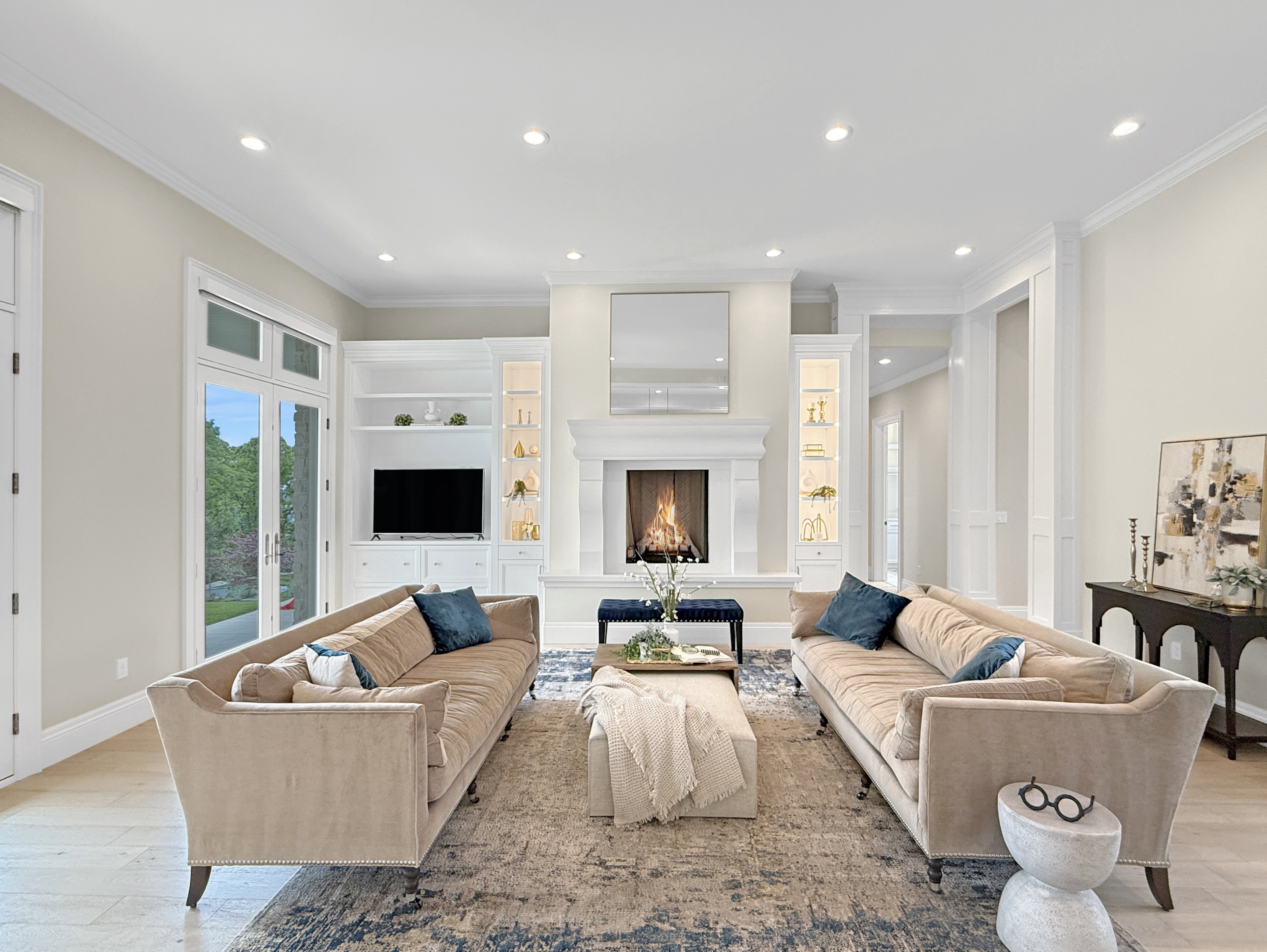 Living area with ornamental molding, recessed lighting, light wood finished floors, a warm lit fireplace, and baseboards