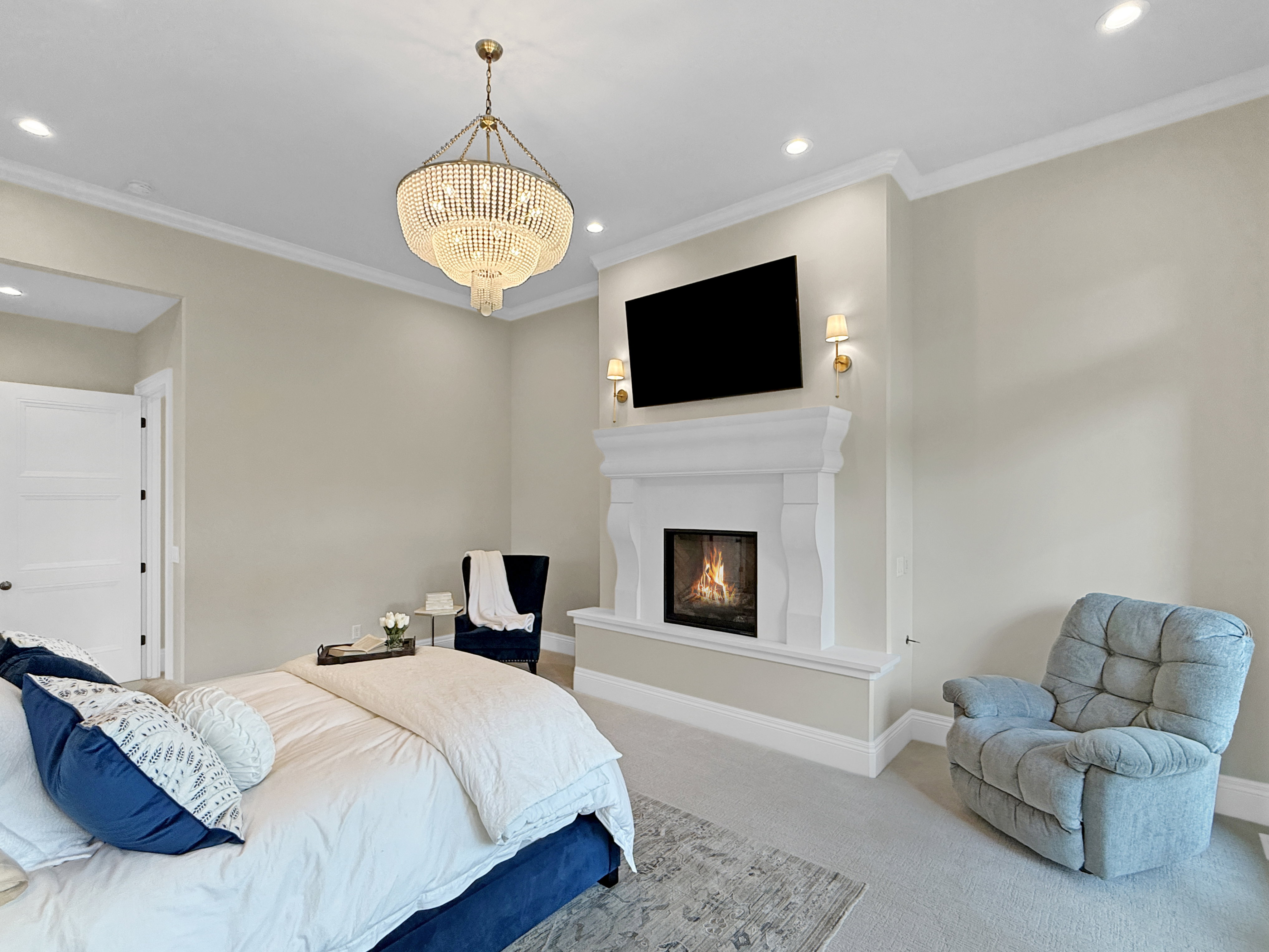 Carpeted bedroom with recessed lighting, a glass covered fireplace, crown molding, baseboards, and a chandelier