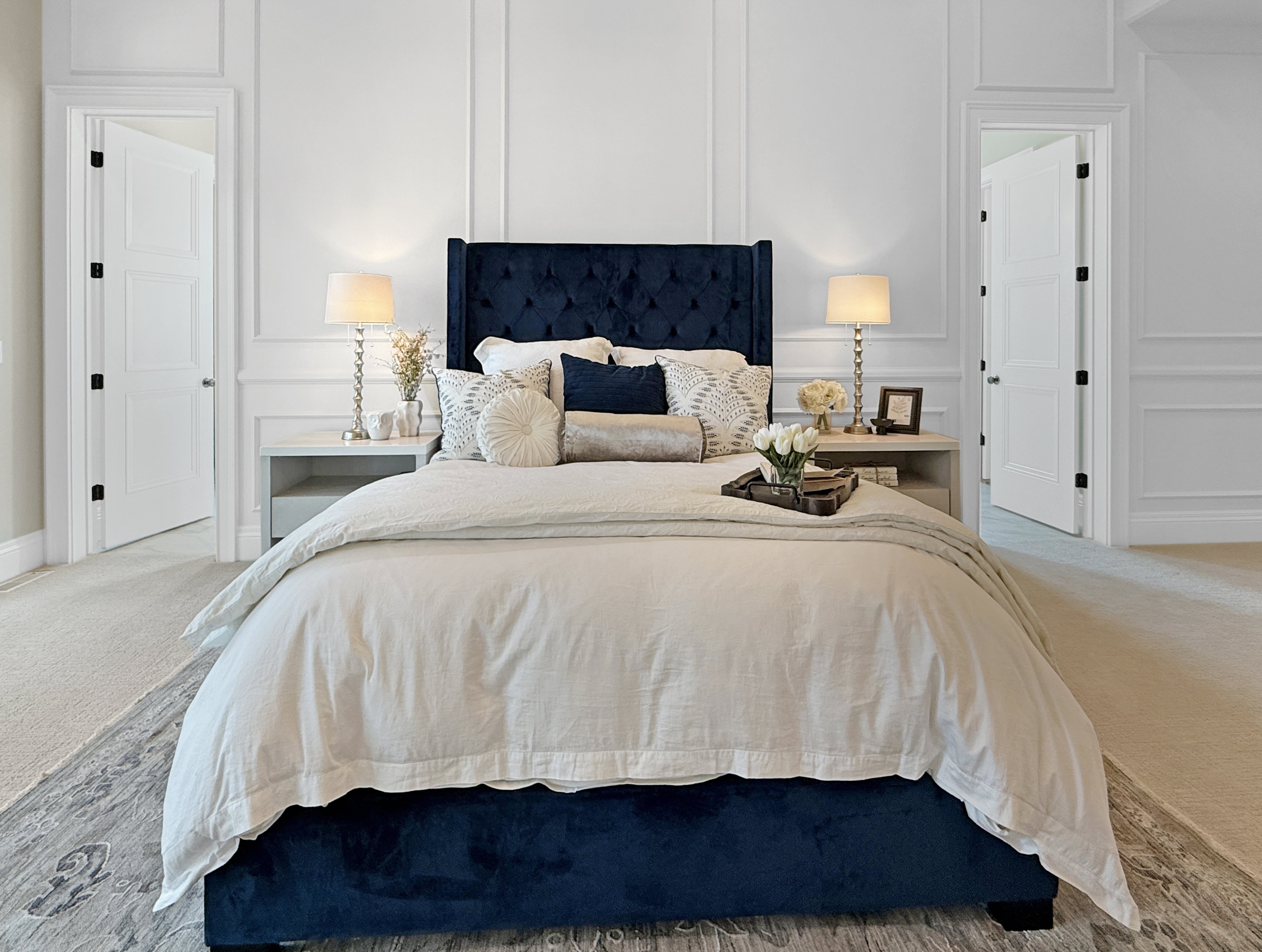 Bedroom featuring a decorative wall, carpet flooring, and baseboards