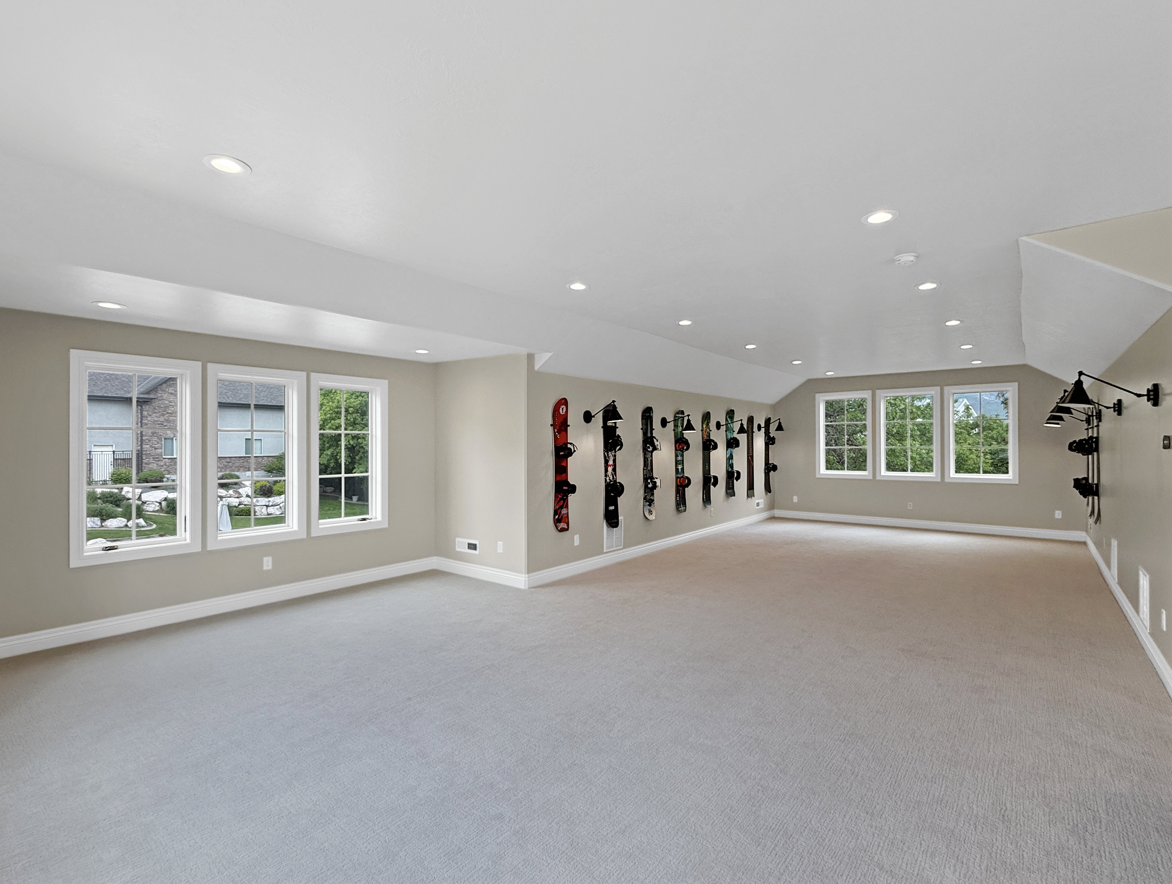 Above garage living room featuring carpet floors, vaulted ceiling, baseboards, and recessed lighting