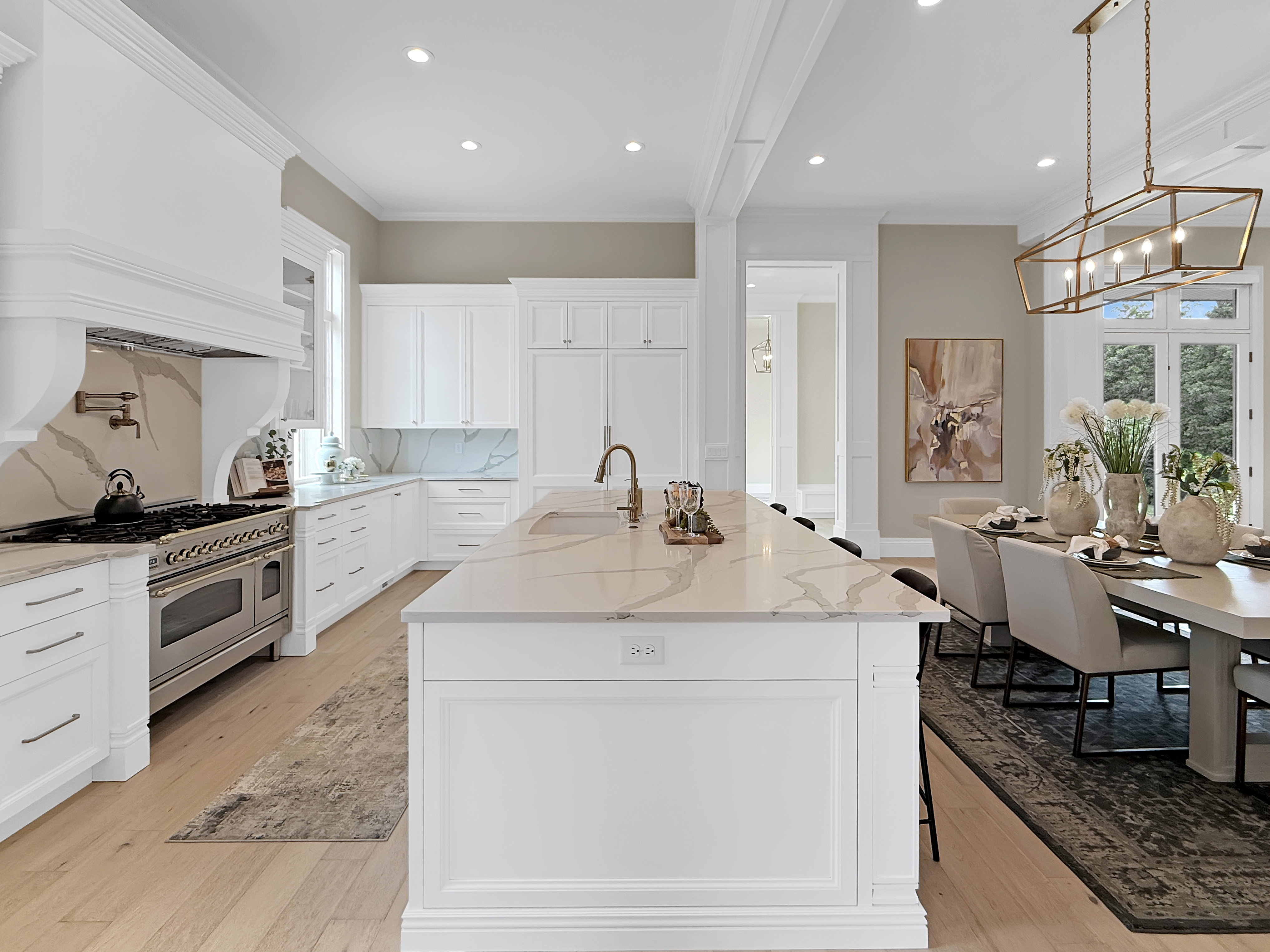 Kitchen featuring oven range, a sink, crown molding, light wood-style floors, and a chandelier