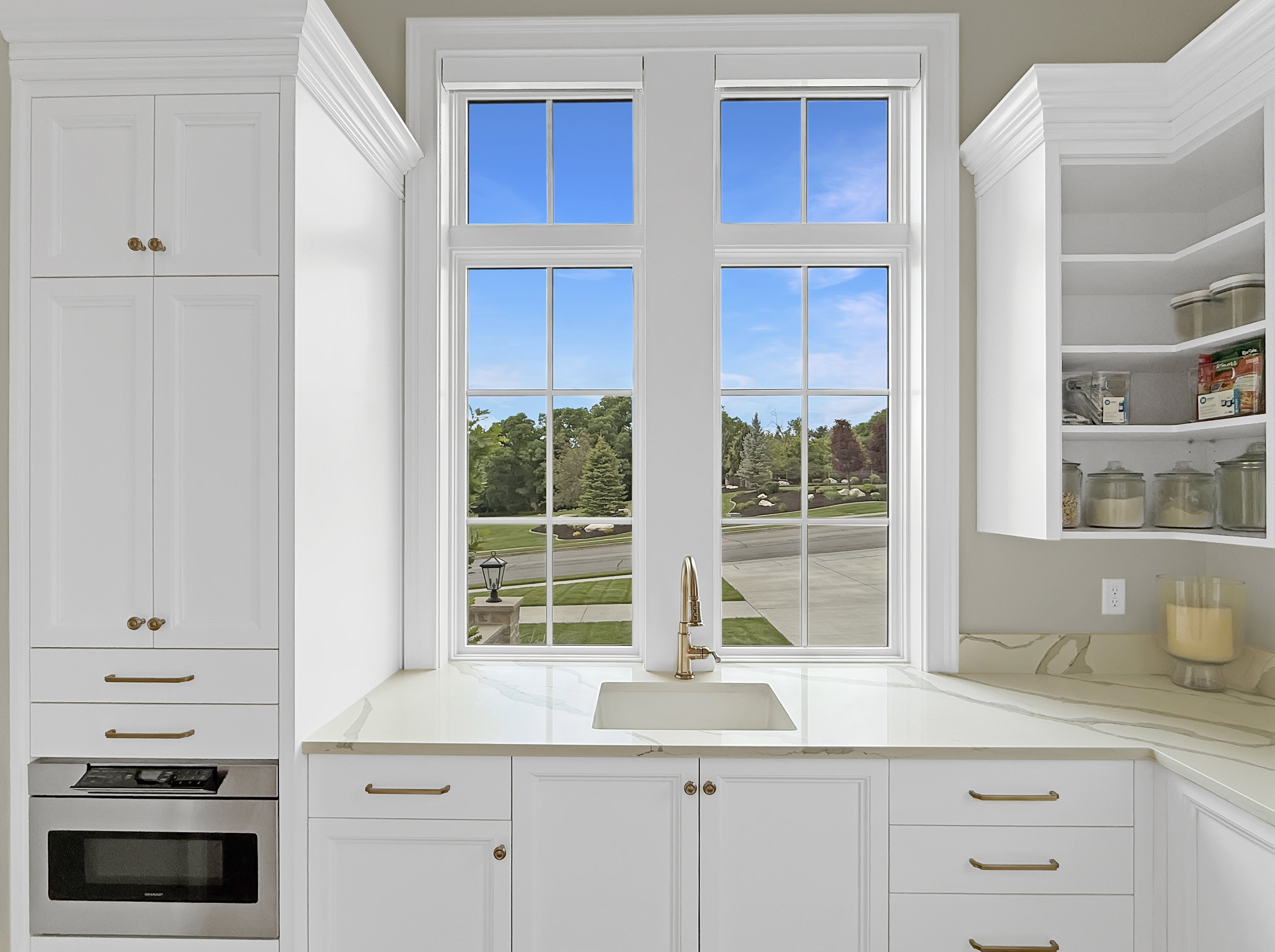 Kitchen featuring stainless steel oven, a sink, and white cabinets