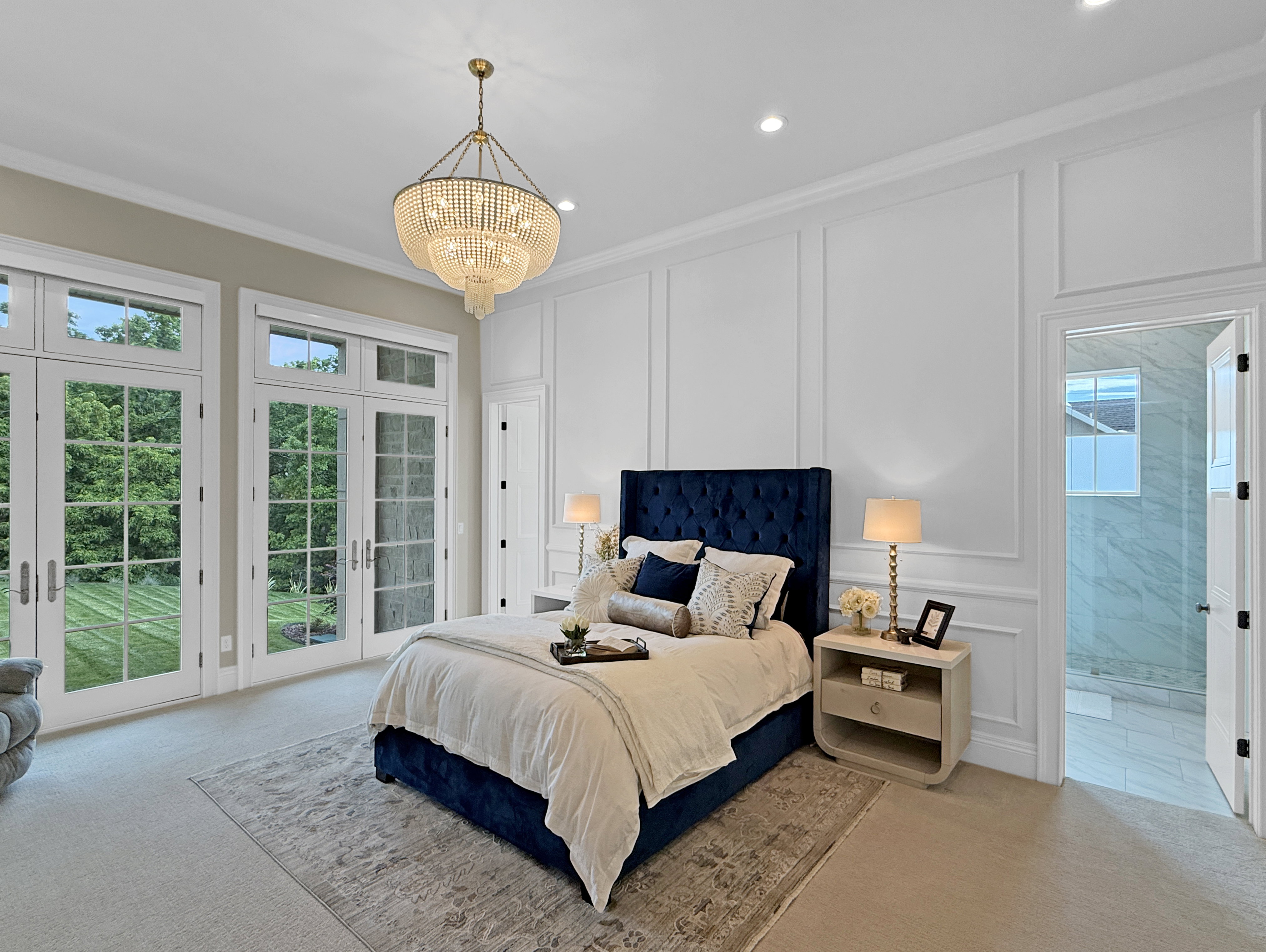 Carpeted bedroom featuring a decorative wall, access to exterior, a chandelier, ornamental molding, and french doors
