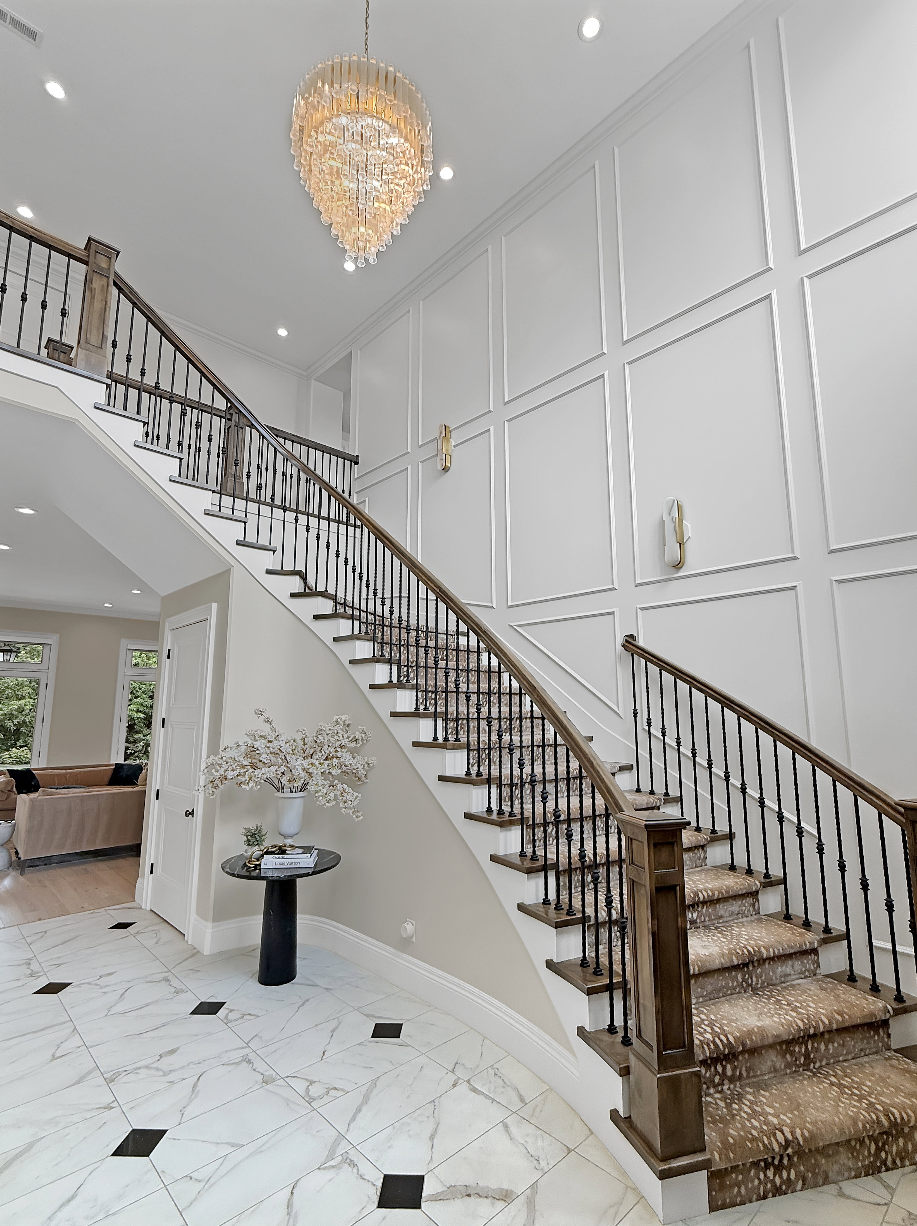 Stairs featuring a decorative wall, marble finish flooring, a chandelier, baseboards, and recessed lighting