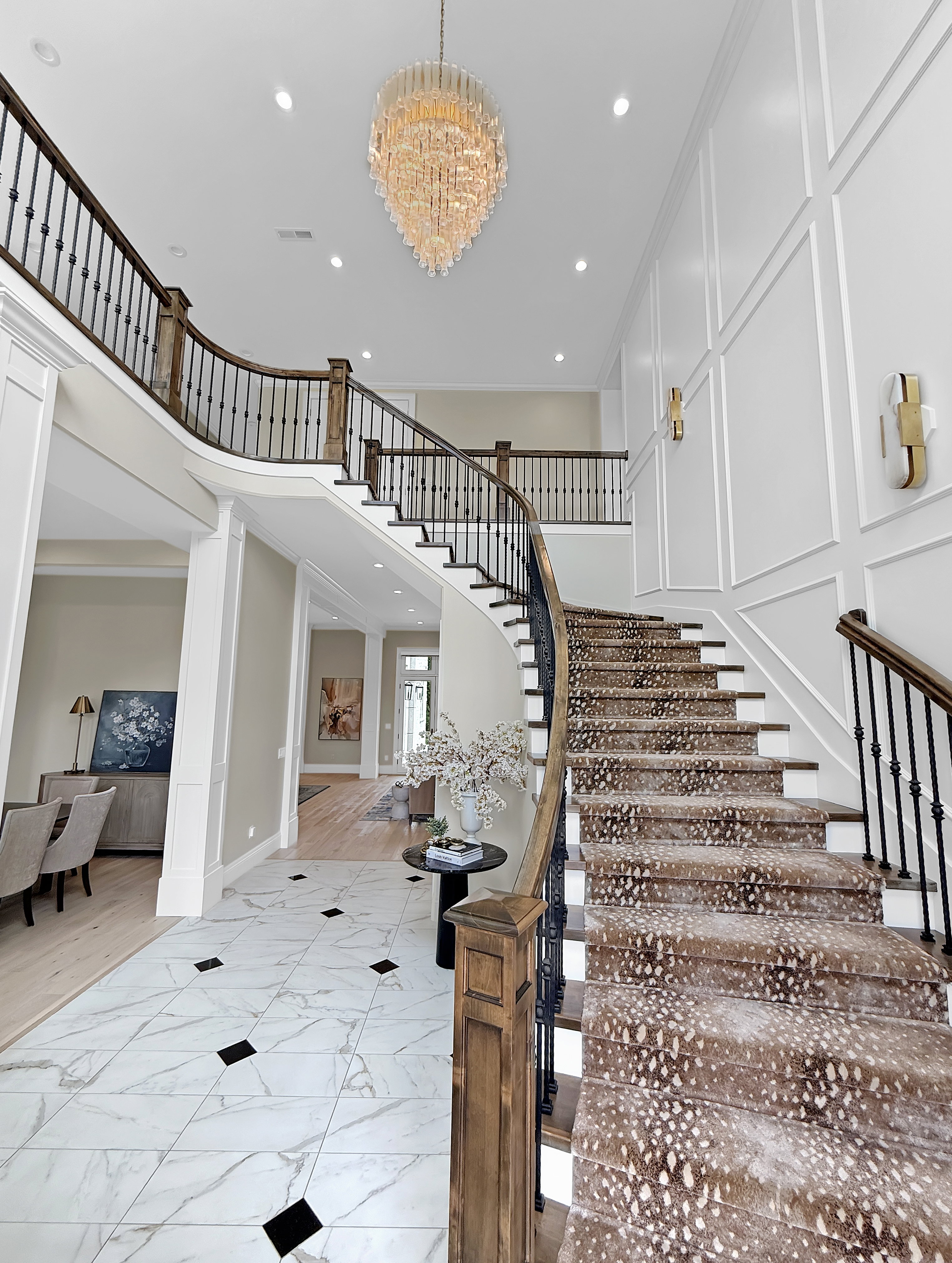 Stairs with marble finish flooring, a chandelier, recessed lighting, baseboards, and a high ceiling