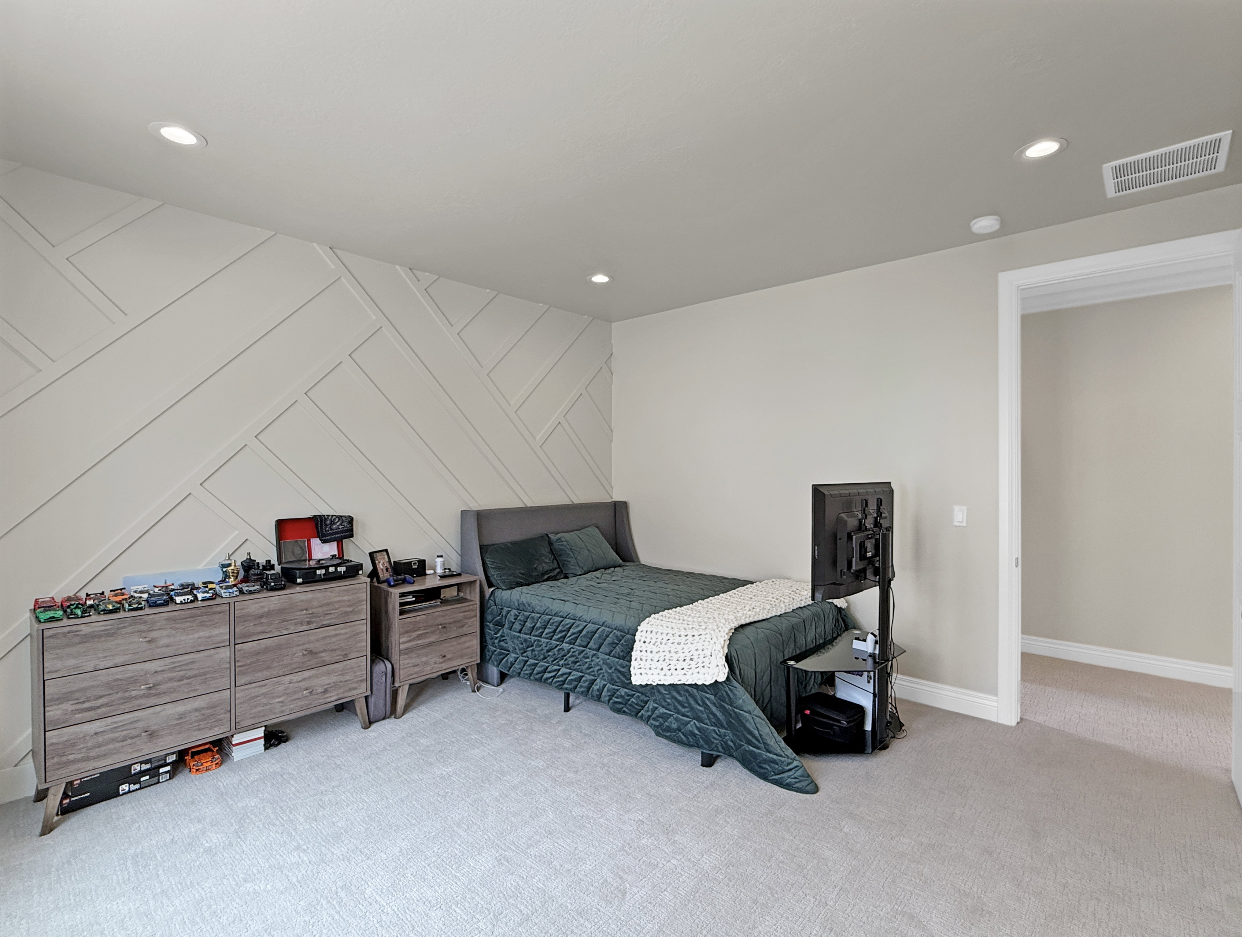 Bedroom with carpet flooring, recessed lighting, baseboards, and a decorative wall