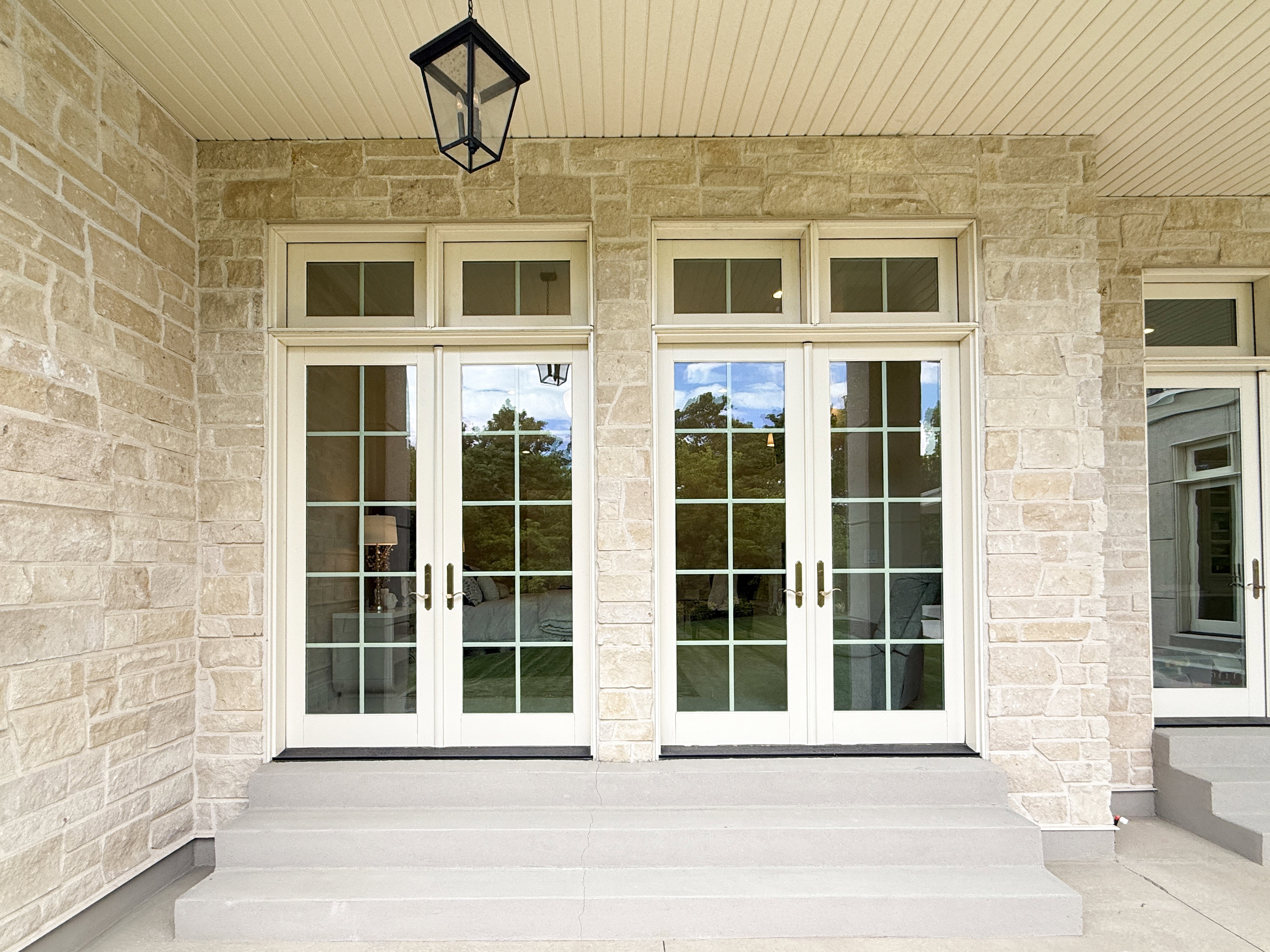 Property entrance featuring french doors and stone siding