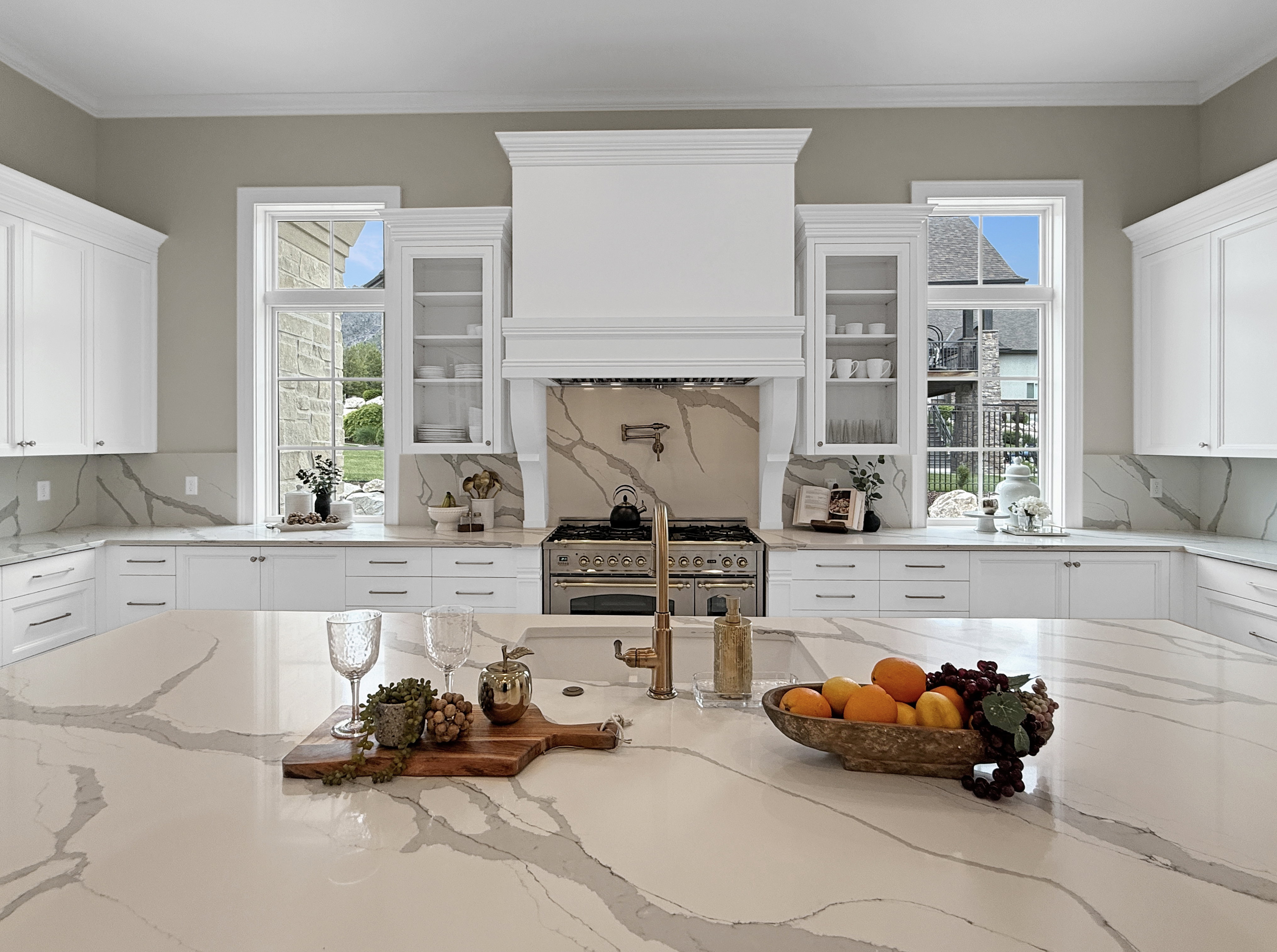 Kitchen featuring range. white cabinets, decorative backsplash, and crown molding