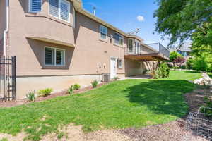 Back of property with a wooden deck, stairs, and stucco siding