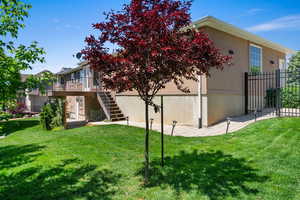 Rear view of house featuring stairway, a deck, and stucco siding