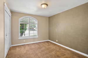 Carpeted empty room with baseboards
