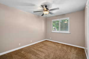 Unfurnished room with carpet floors, ceiling fan, and baseboards