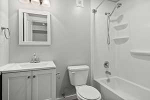 Bathroom with toilet, vanity, and shower / washtub combination